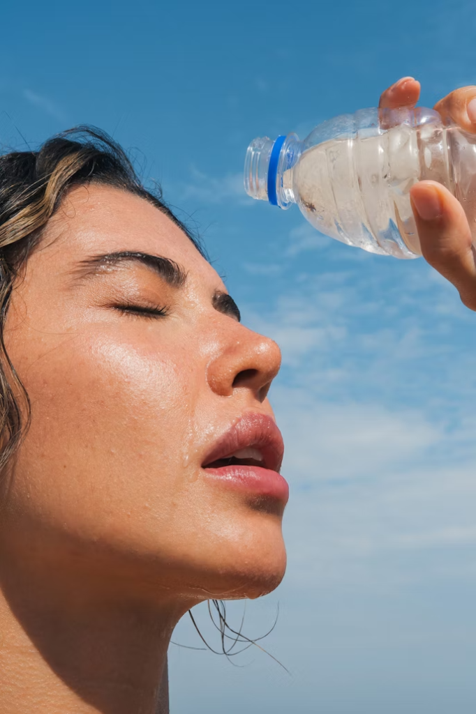 Mujer hidratándose en verano para evitar retrasos menstruales, recomendación de Femilady
